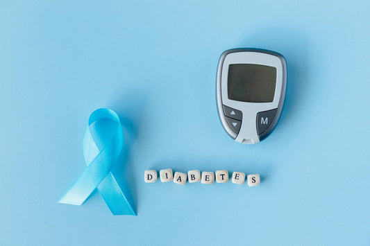 Сина лента, глукометар и буквички што го формираат зборот „diabetes“ на светло сина подлога, симболизирајќи свесност за дијабетес тип 2.